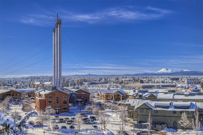 A power plant and houses in Bend covered in snow.